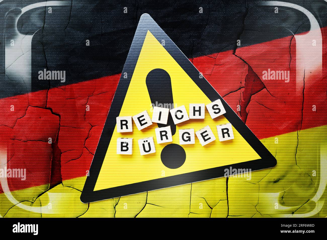 Buchstabenwürfel formen das Wort Reichsbürger auf Gefahrenschild und Deutschlandfahne Stock Photo