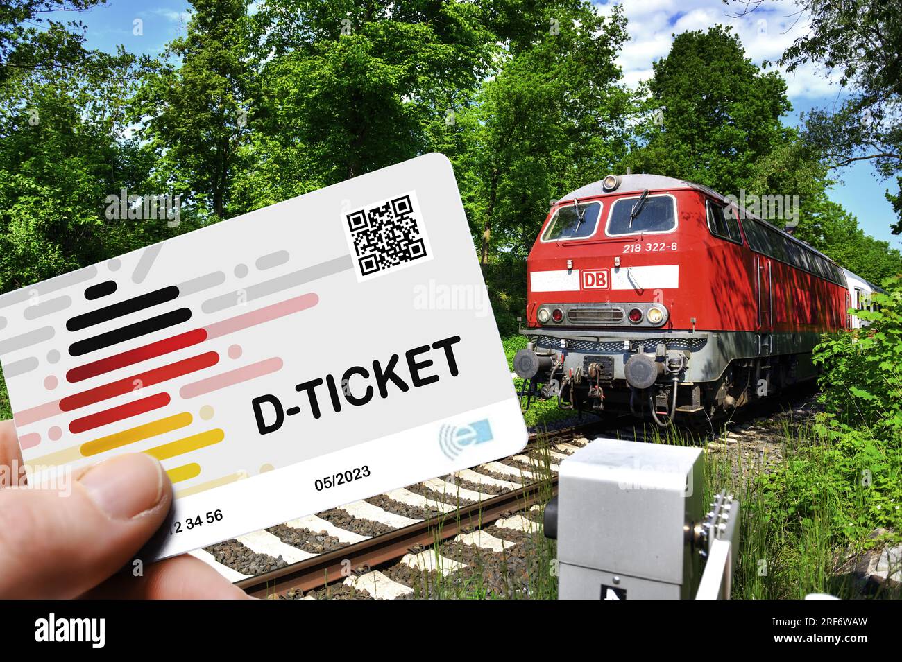 FOTOMONTAGE, Hand hält das Deutschlandticket D-Ticket vor einer Regionalbahn Stock Photo