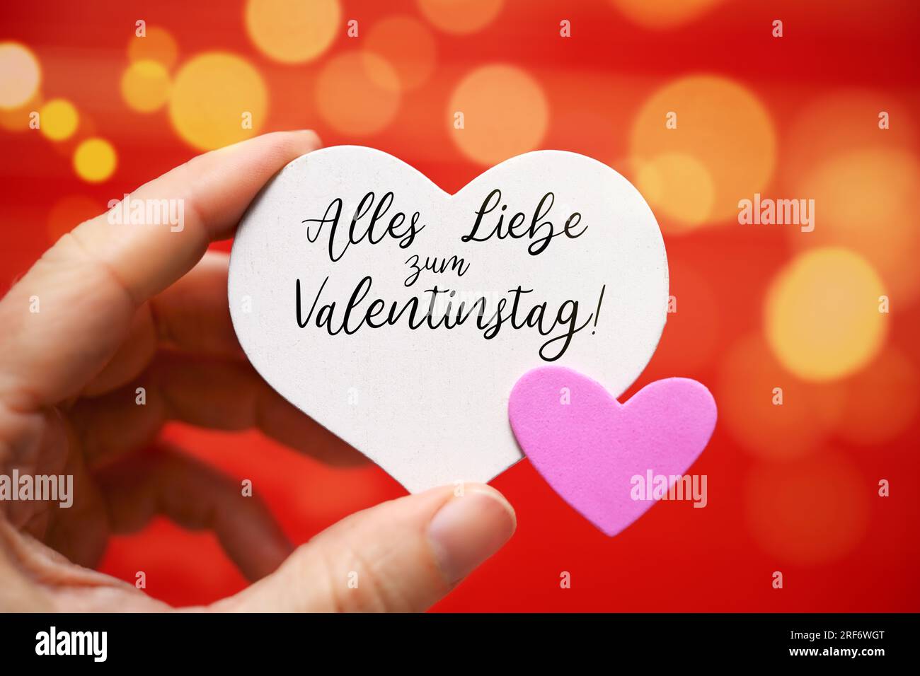 FOTOMONTAGE, Hand hält Herzen mit Aufschrift Alles Liebe zum Valentinstag Stock Photo