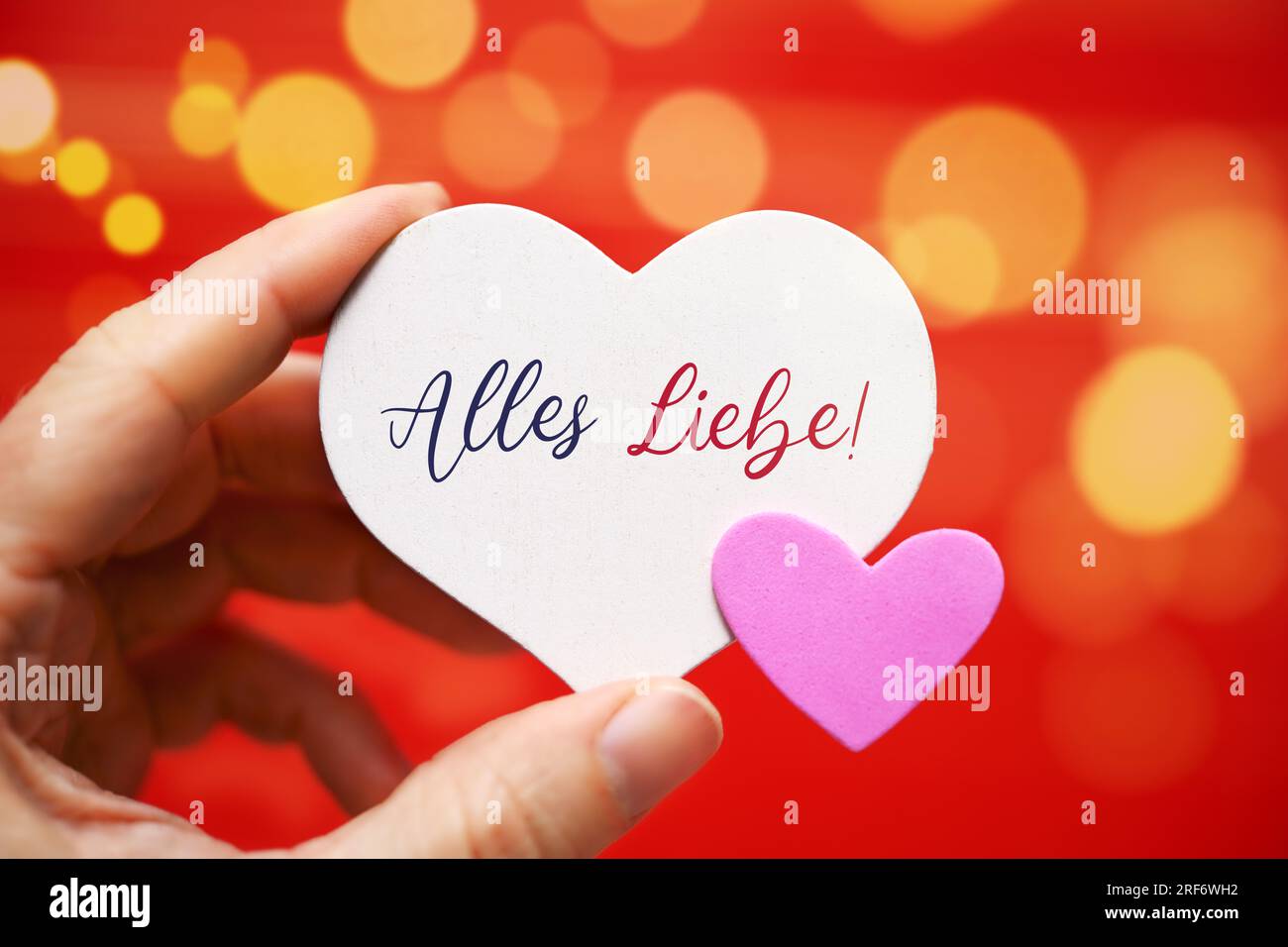 FOTOMONTAGE, Hand hält Herzen mit Aufschrift Alles Liebe, Symbolfoto Valentinstag Stock Photo