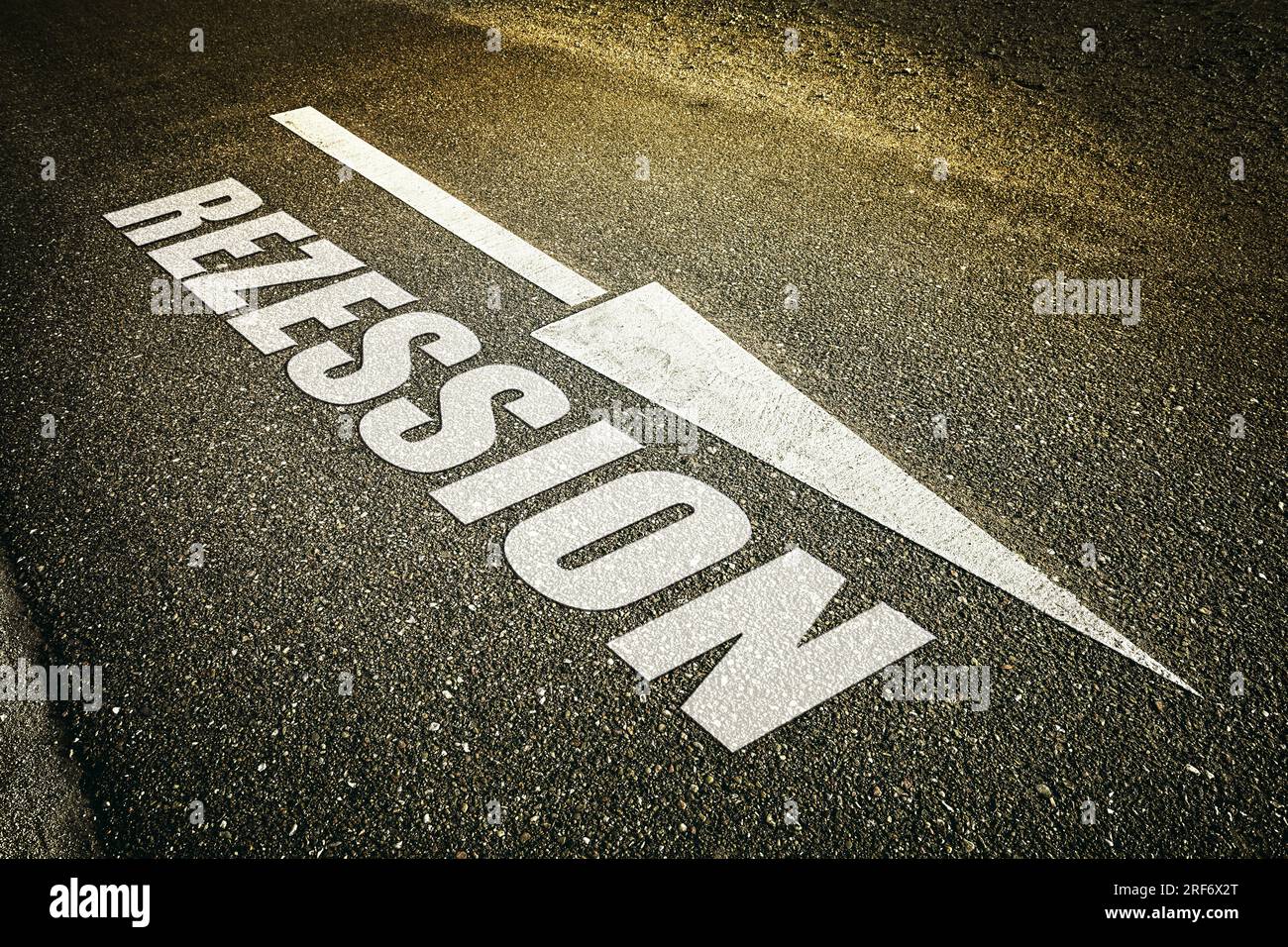 FOTOMONTAGE, Absteigendes Pfeilsymbol auf Straßenasphalt und Schriftzug Rezession, Symbolfoto Wirtschaftskrise Stock Photo