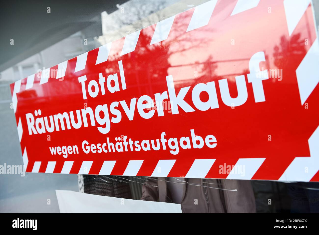 Schild Total-Räumungsverkauf wegen Geschäftsaufgabe in einem Schaufenster Stock Photo