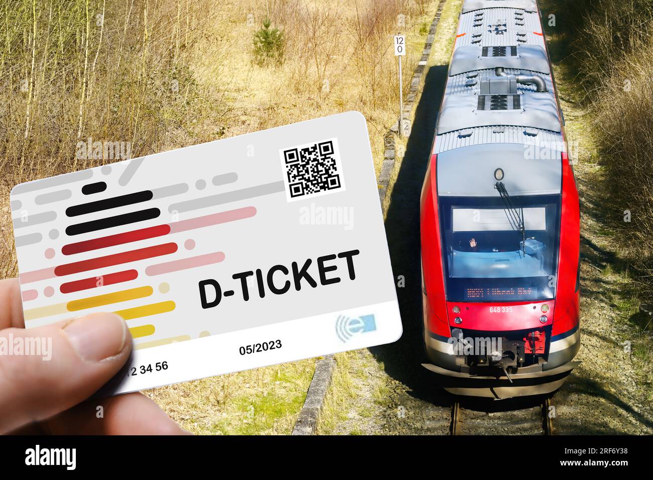 FOTOMONTAGE, Hand hält das Deutschlandticket D-Ticket vor einer Regionalbahn Stock Photo