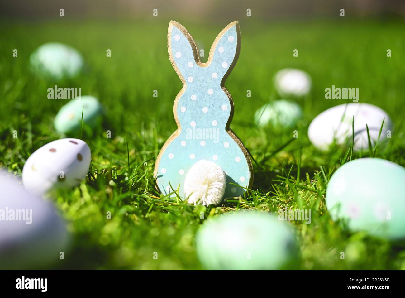 Osterhasenfigur mit Ostereiern auf dem Rasen Stock Photo