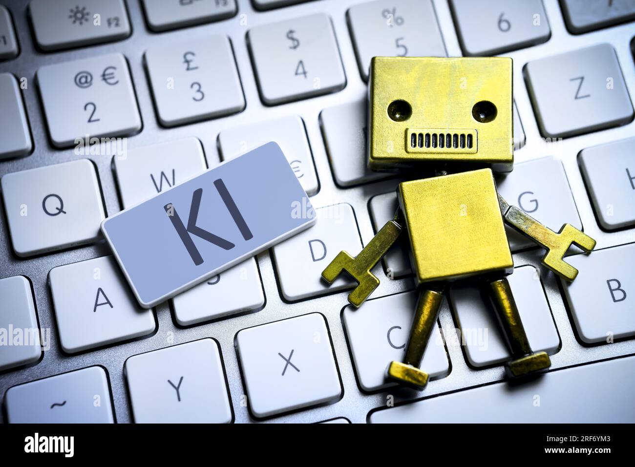 FOTOMONTAGE, Roboterfigur auf einer Computertastatur und Taste mit Aufschrift KI Stock Photo