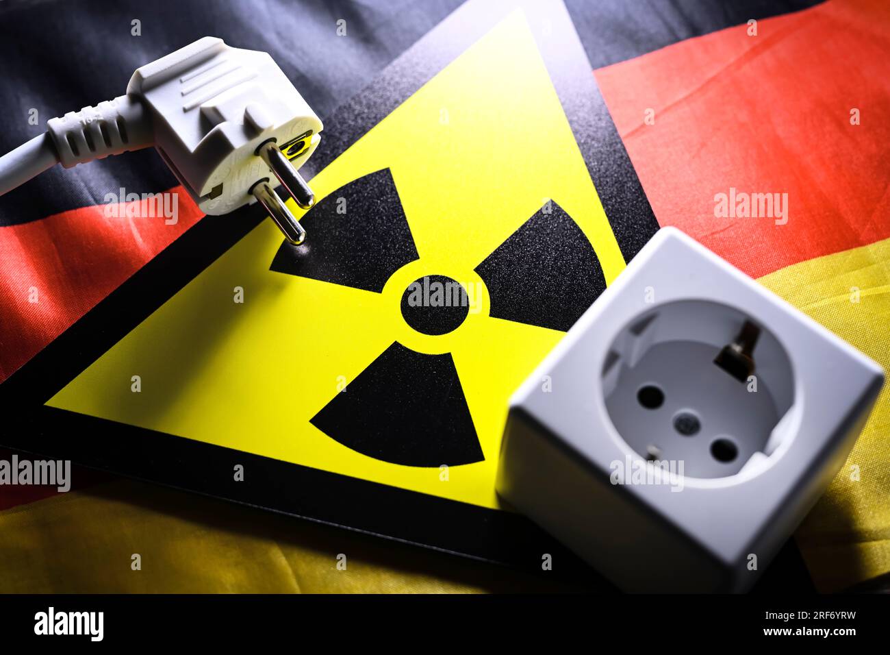 Schild mit Radioaktivitätssymbol und Steckdose und Stecker auf Deutschlandfahne, Symbolfoto für AKW-Abschaltung Stock Photo