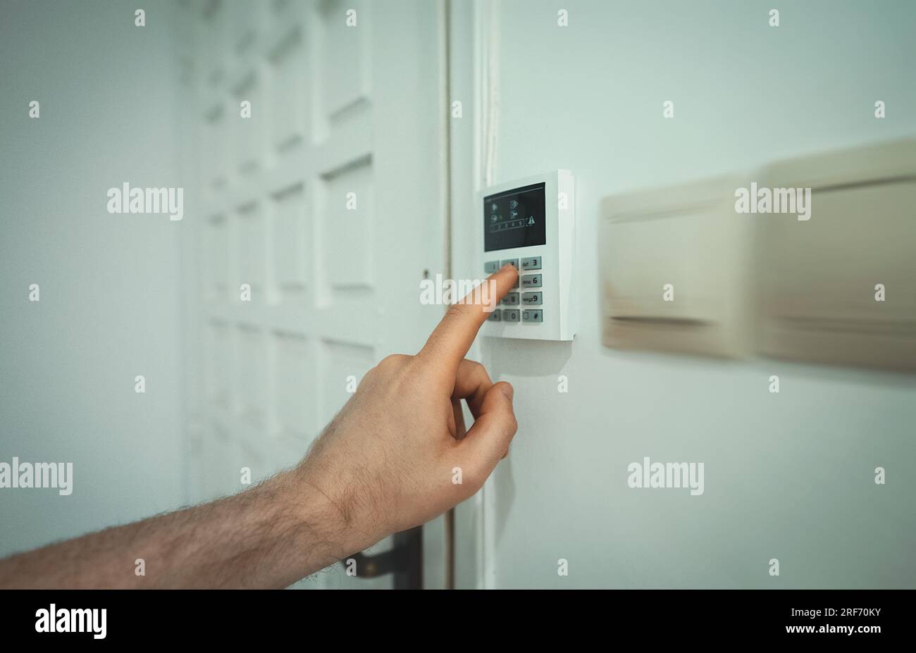 Man putting code in alarm system panel at home. Stock Photo