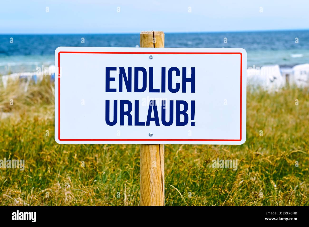 FOTOMONTAGE, Schild am Meer mit Aufschrift Endlich Urlaub Stock Photo