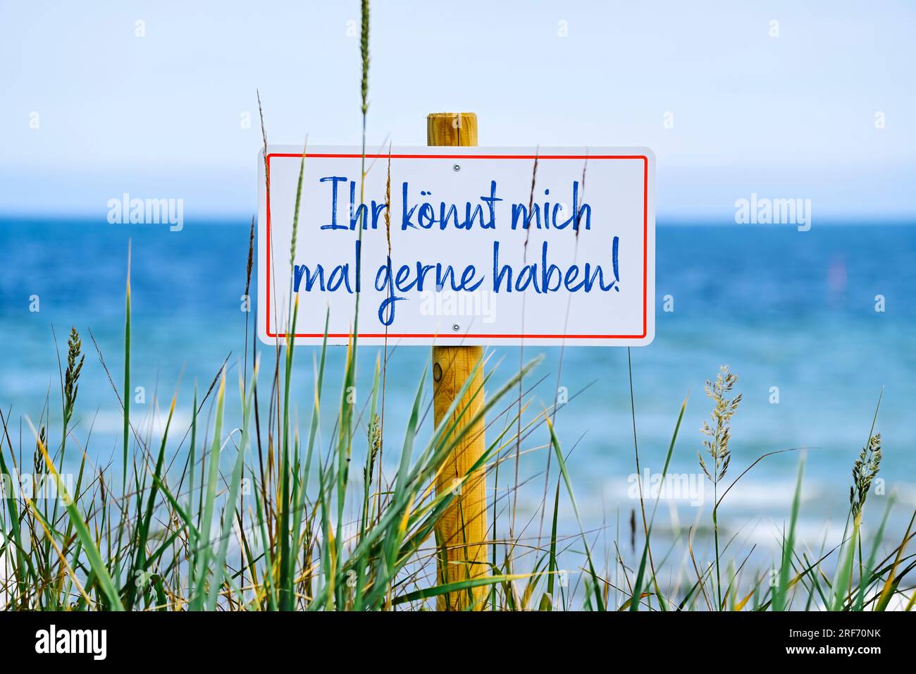 FOTOMONTAGE, Schild am Meer mit Aufschrift Ihr könnt mich mal gerne
