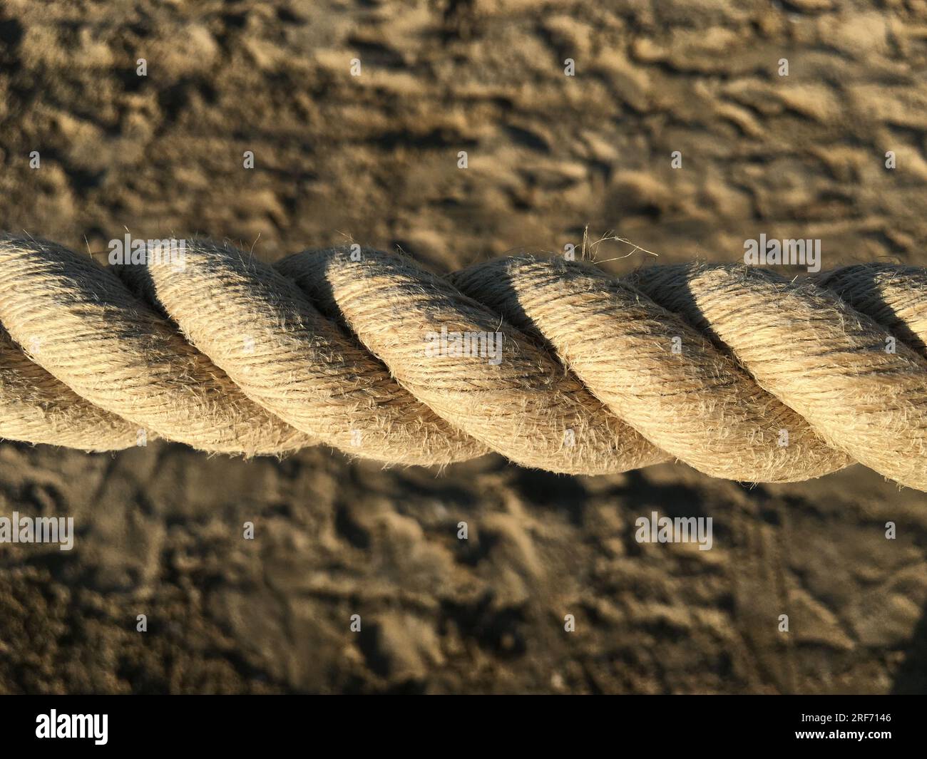 Close-up of old frayed boat rope as a background, rope on the background of sand Stock Photo