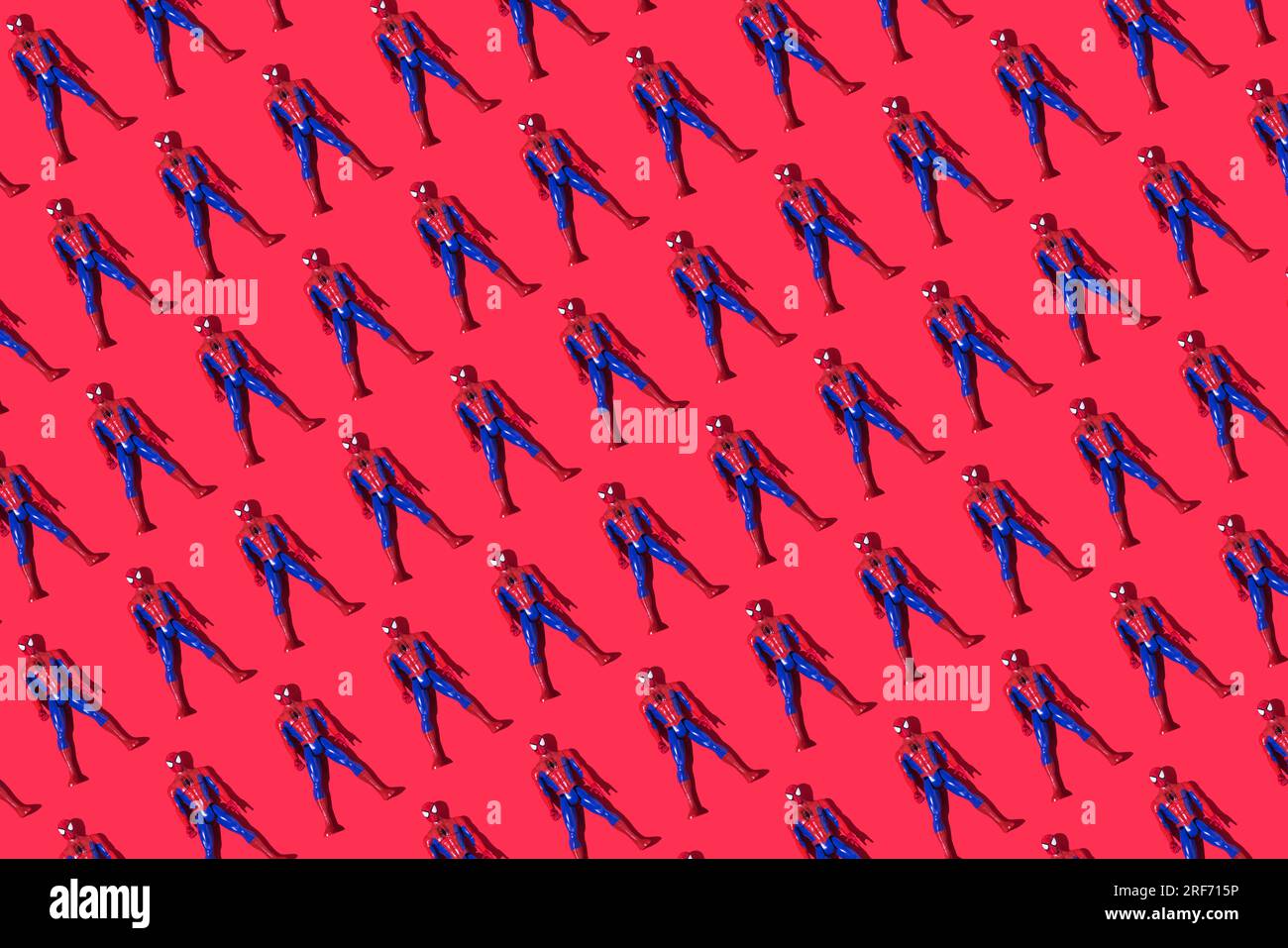 Pattern of Marvel and Sony spiderman dolls on a red background. Comic
