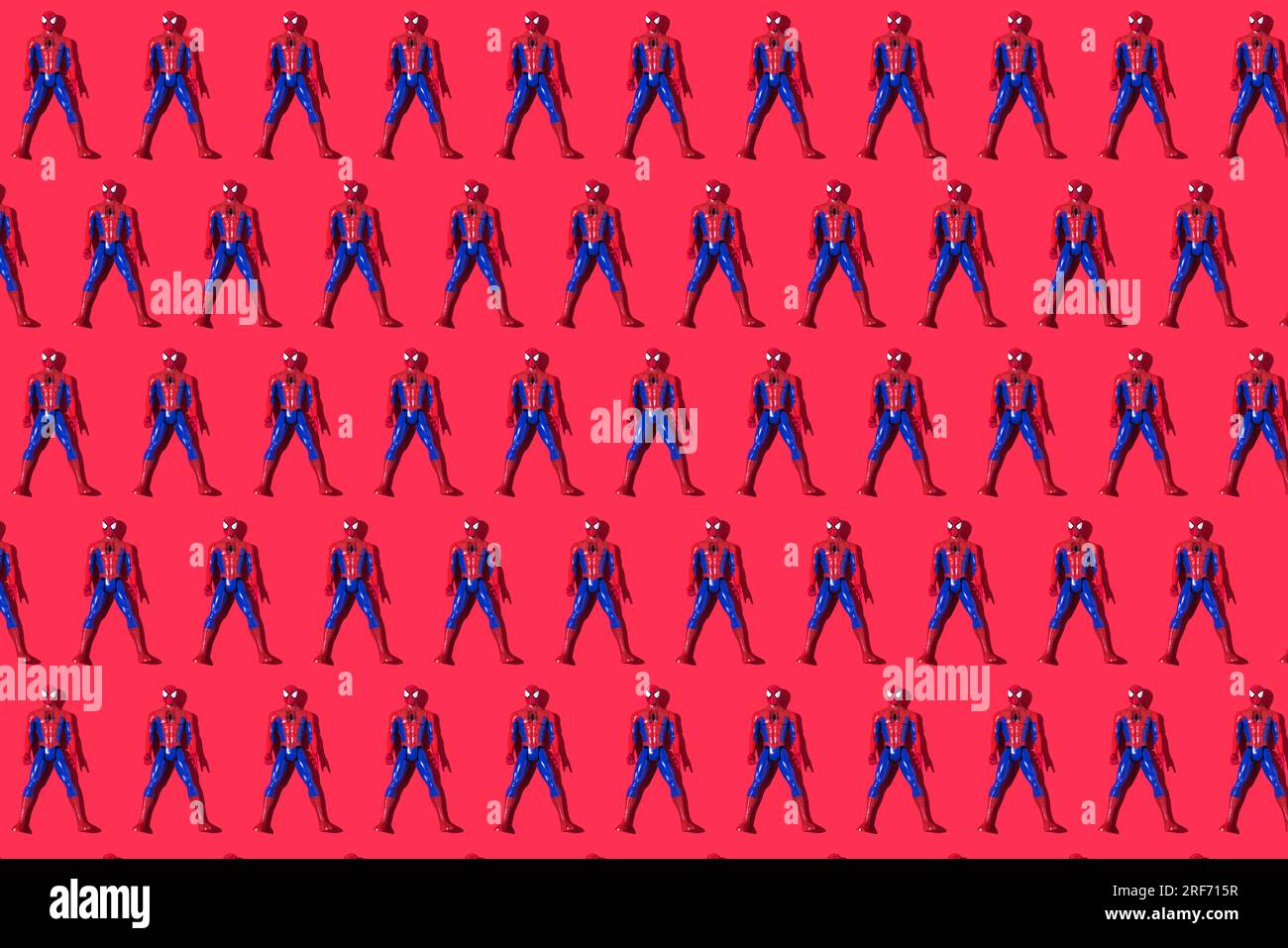 Pattern of Marvel and Sony spiderman dolls on a red background. Comic, superhero, spider, spider-man, mask and editorial concept. Stock Photo
