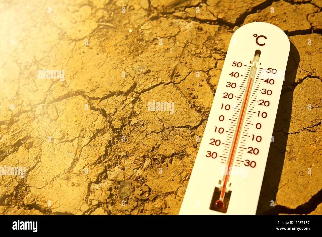 Thermometer liegt auf gerissener Erde, Symbolfoto Sommerhitze Stock Photo