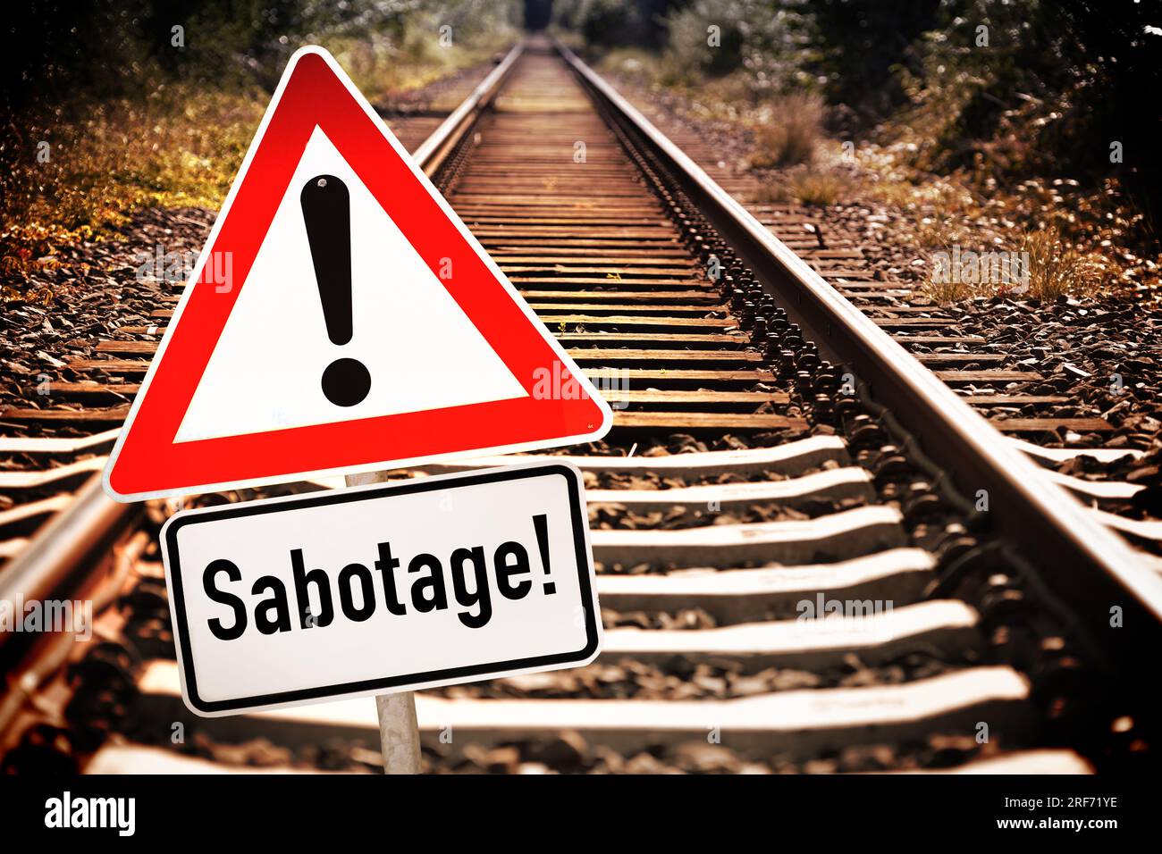 FOTOMONTAGE, Leere Bahngleise und Gefahrenschild mit der Aufschrift Sabotage Stock Photo