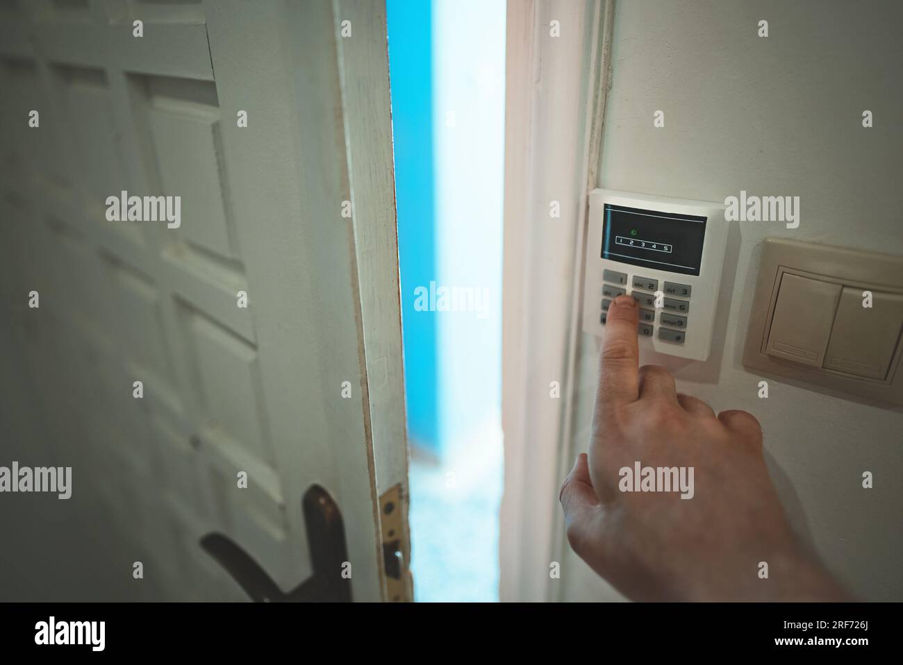 Man putting code in alarm system panel at home. Stock Photo
