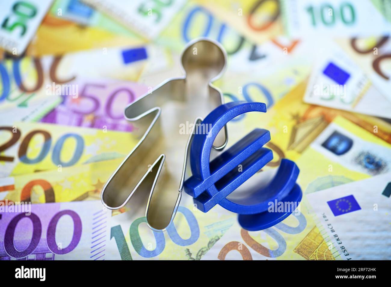 Figur mit Eurozeichen und Geldscheinen, Symbolfoto Bürgergeld Stock Photo