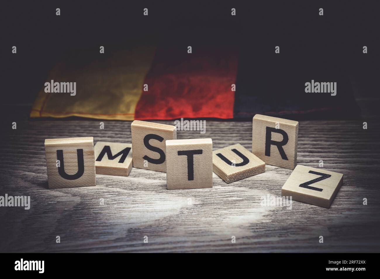 Buchstaben bilden den Schriftzug Umsturz vor einer Deutschlandfahne Stock Photo
