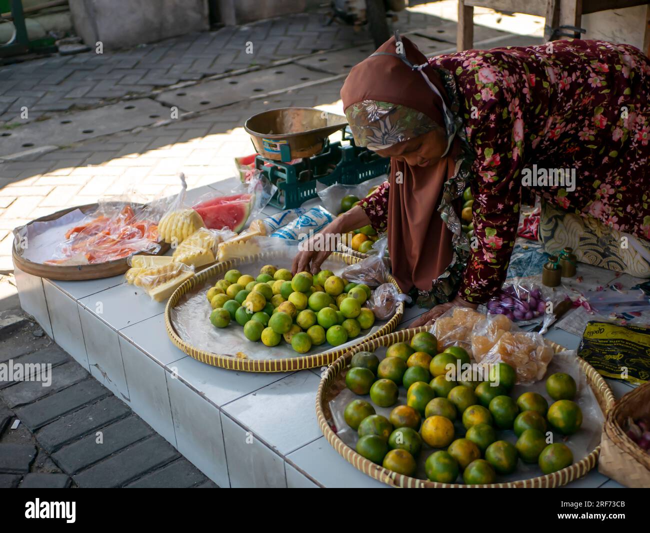 Yogyakarta-Indonesia, July 19, 2023: An old Indonesian woman selling fruits at a traditional market in, Yogyakarta, Indonesia Stock Photo