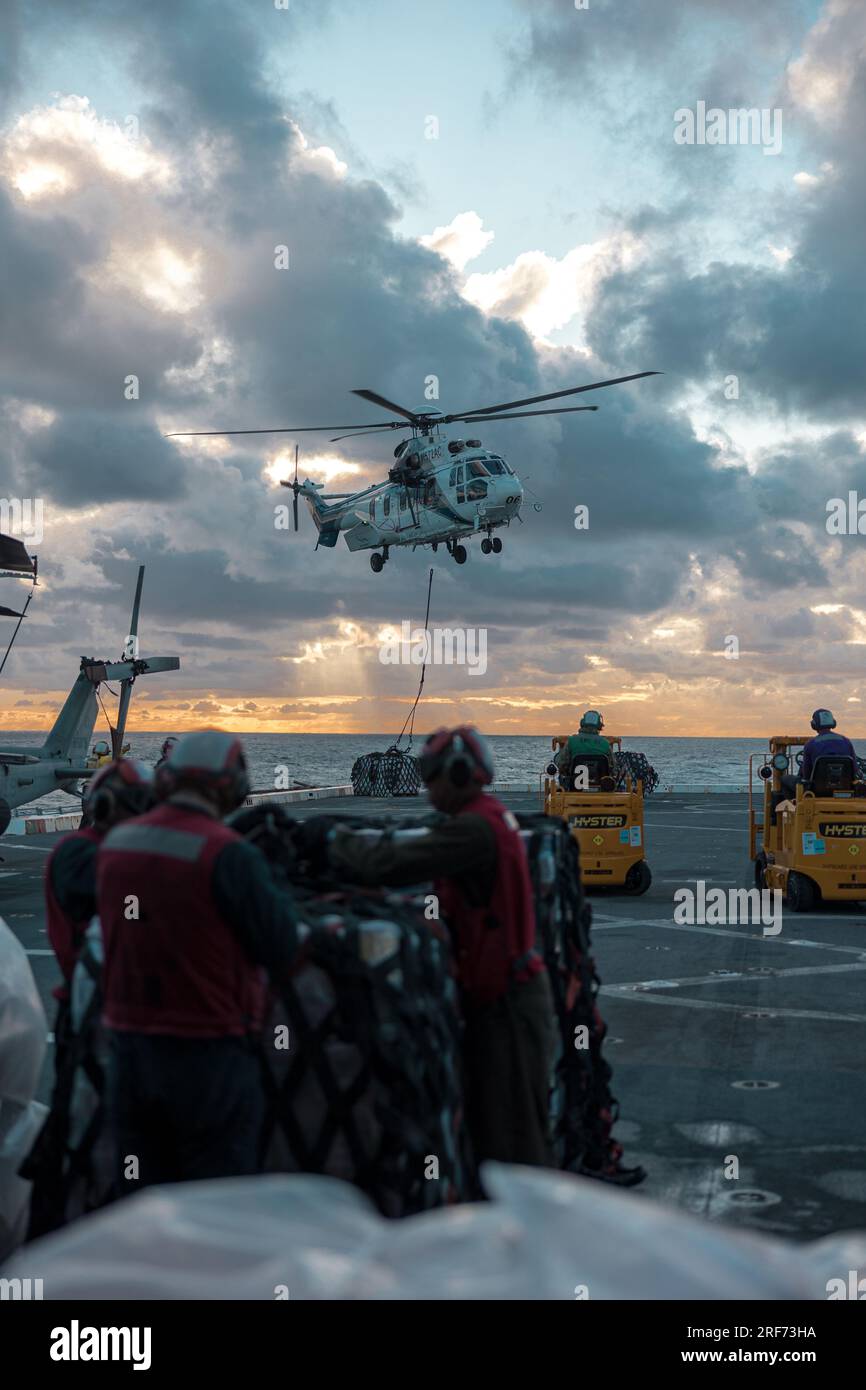 A U.S. Navy sailor guides an EC225 Super Puma helicopter delivering ...