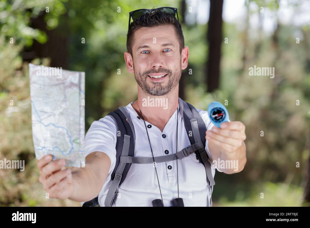male hiker showing map and compass Stock Photo - Alamy