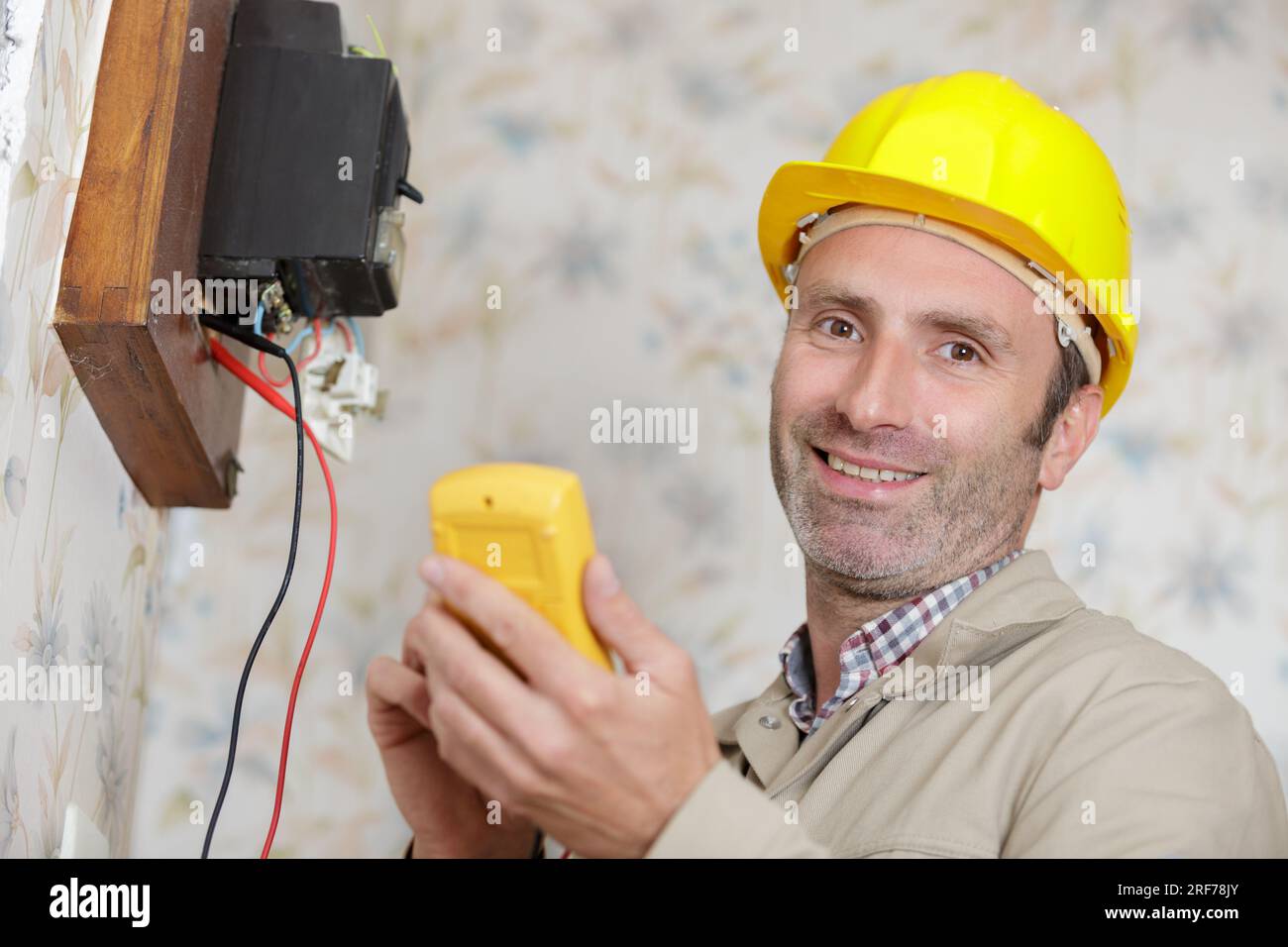 an electrician installs a socket Stock Photo Alamy
