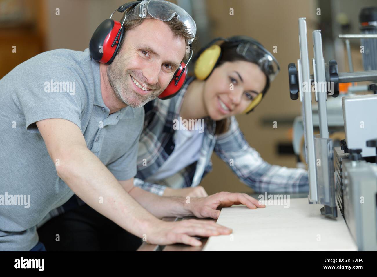 man and woman working in factory wearing ear-defenders Stock Photo
