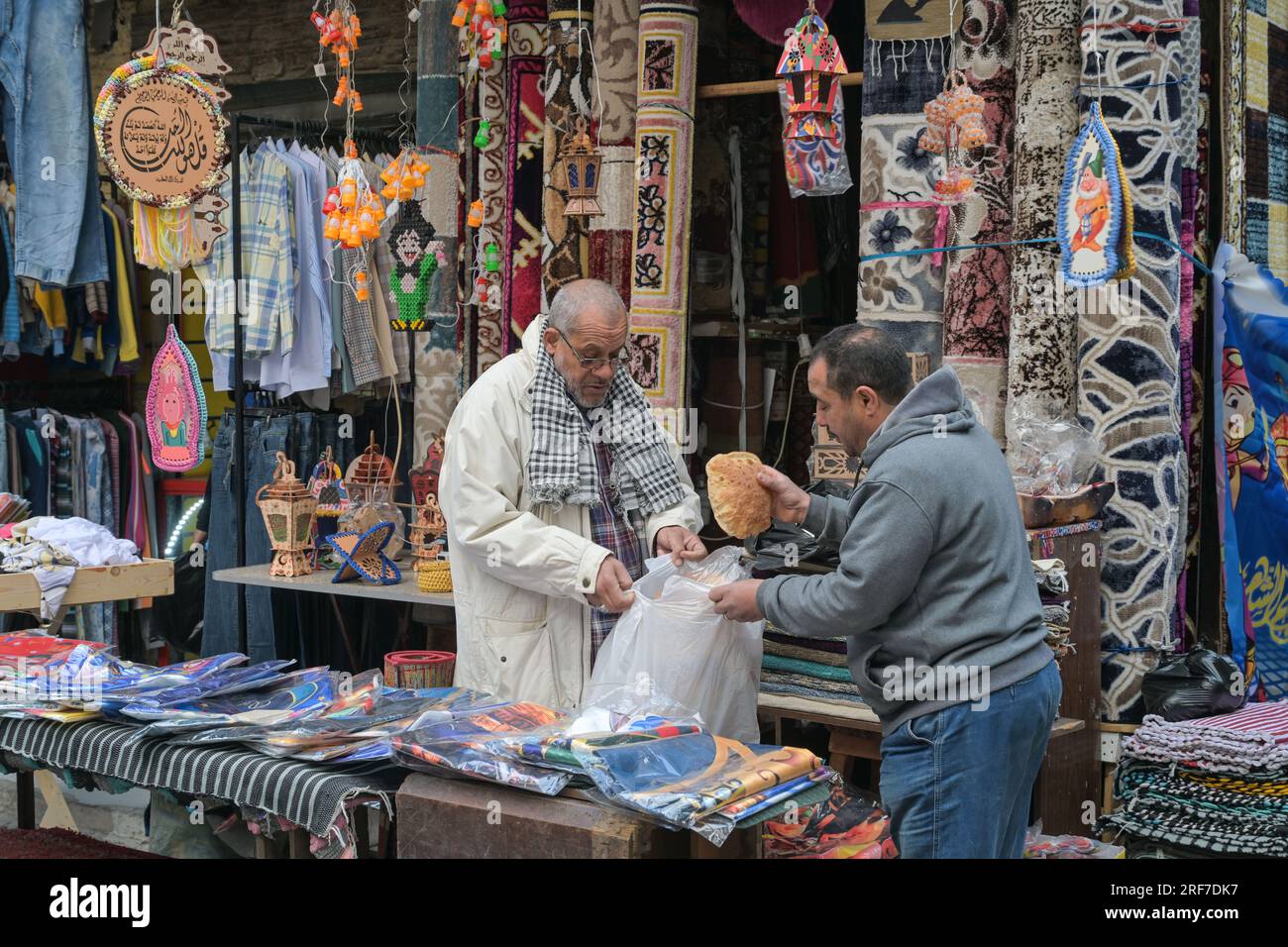 Straßenszene, Textilgeschäft, Teppiche, Männer, Brot, Khan el-Khalili Basar, Altstadt, Kairo, Ägypten Stock Photo