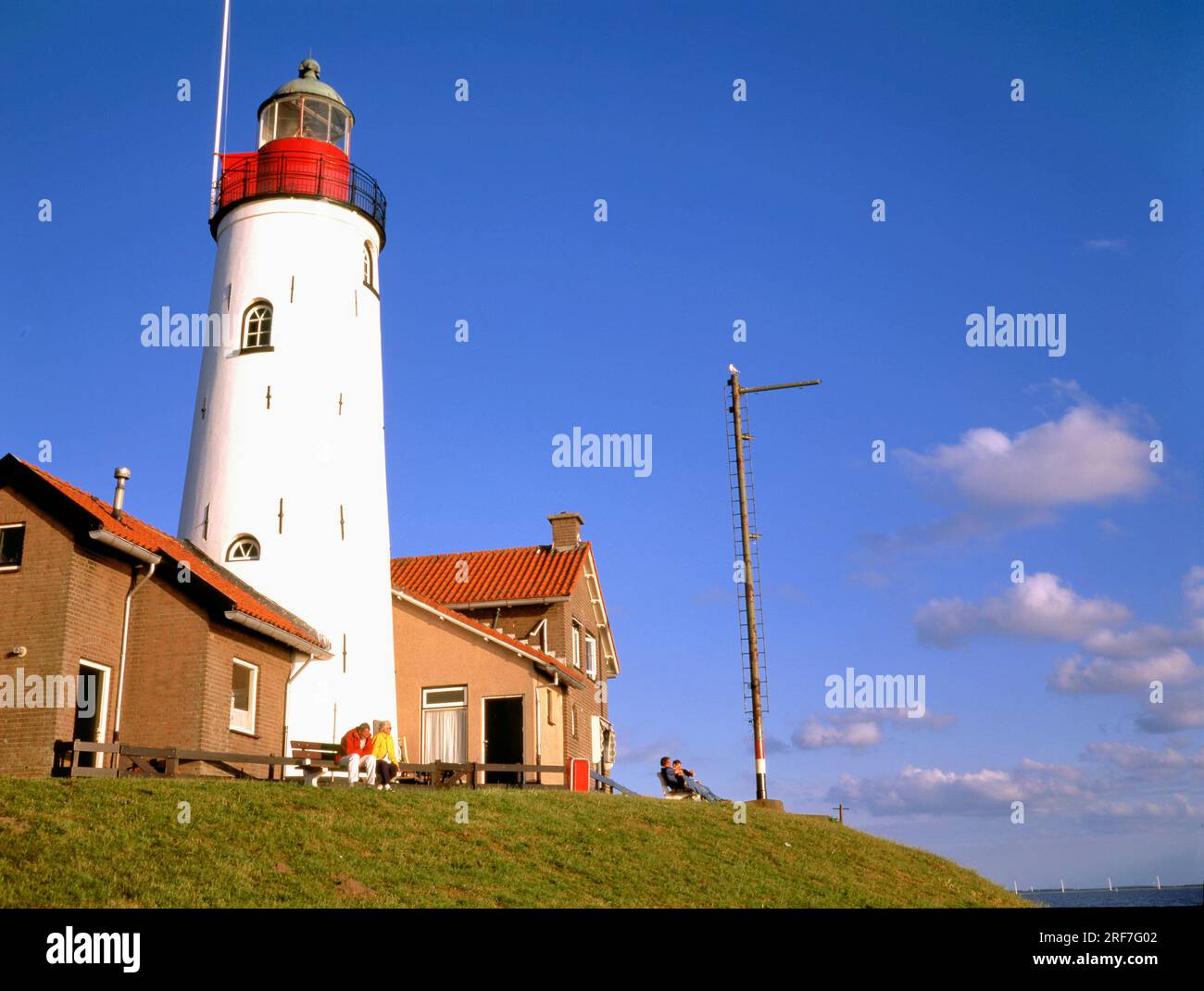 URK,NETHERLANDS-AUGUST 01,2023:The light house of Urk Netherlands alongside the lake Ijselmeer on a bright summer day Stock Photo