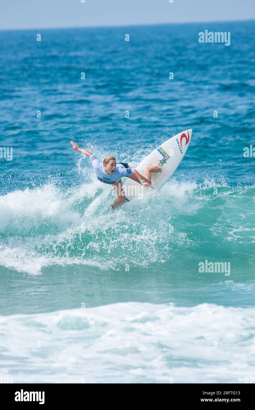 Teenage boys and girls surfing in a junior competition in Newcastle NSW Australia Stock Photo