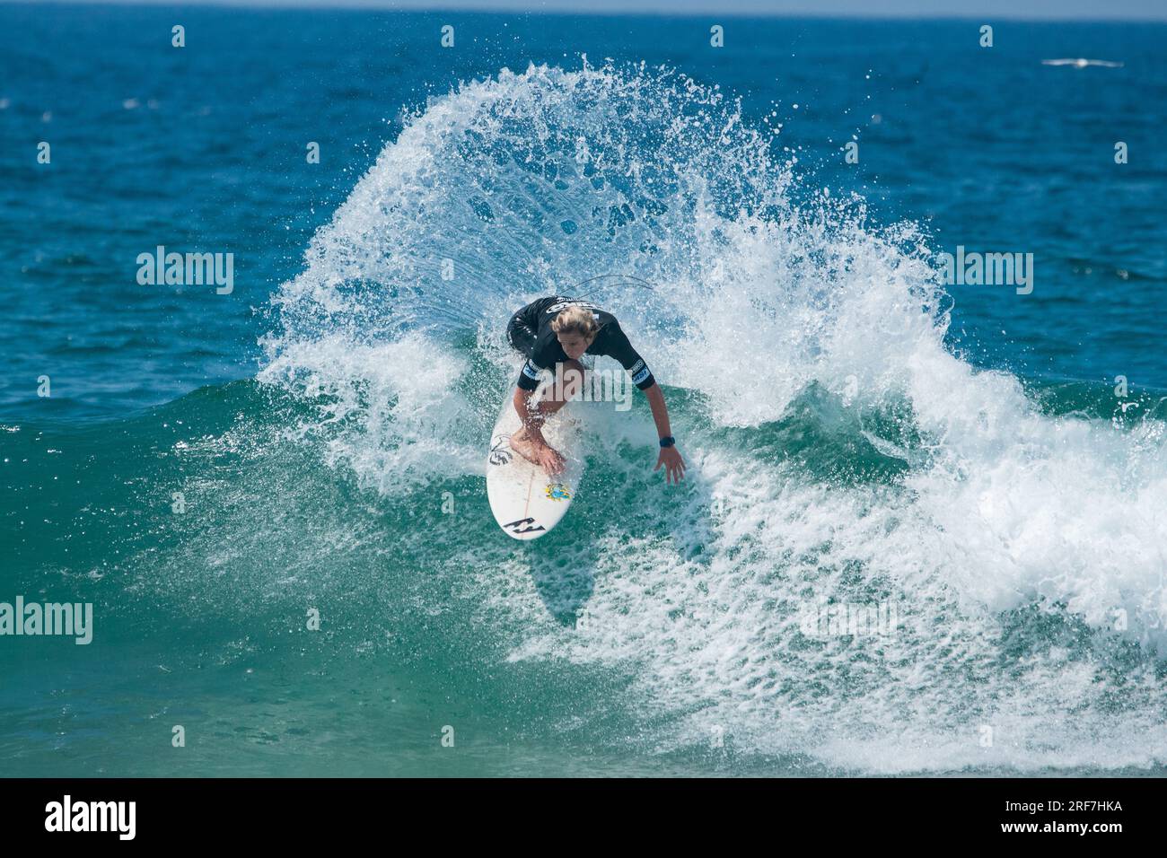 Teenage boys and girls surfing in a junior competition in Newcastle NSW Australia Stock Photo