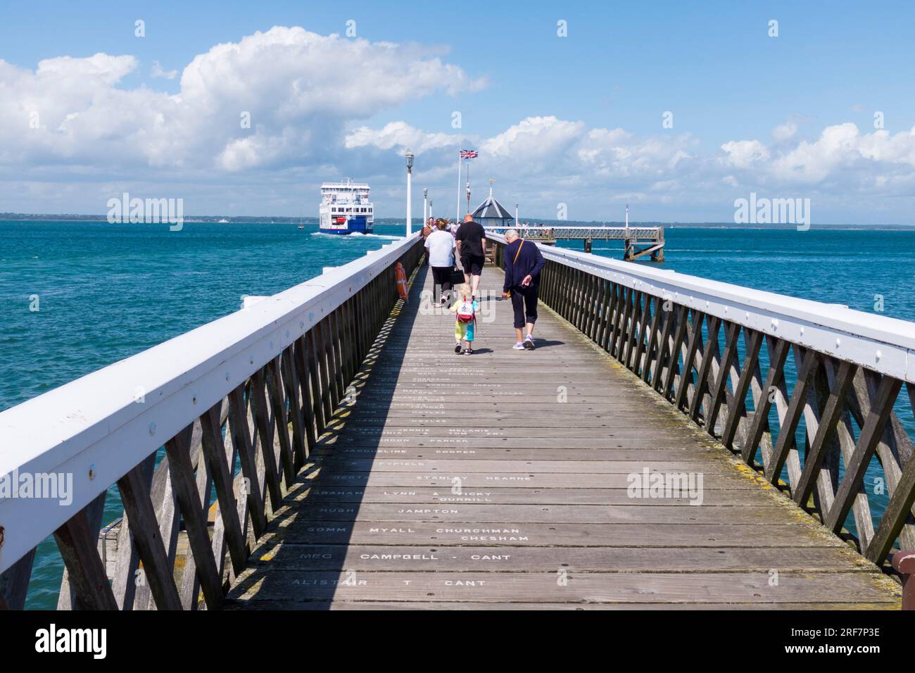 People walking along the pier as the ferry departs at Yarmouth, Isle of Wight, England,UK Stock Photo