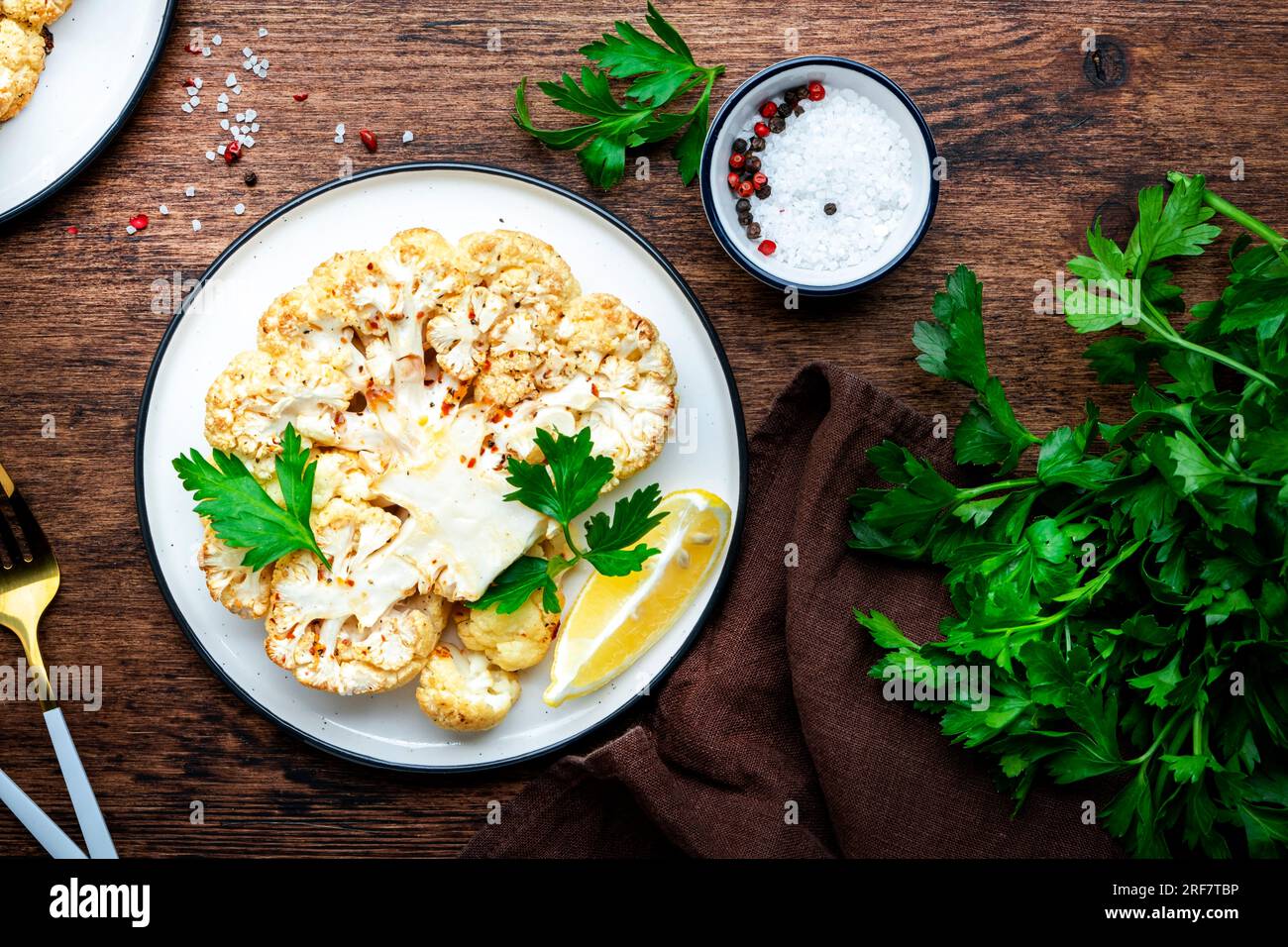 Baked cauliflower vegan steak with garlic butter, parley and spice on