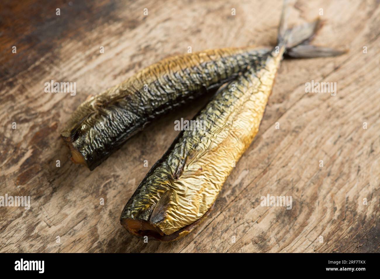 Two hot smoked mackerel, Scomber scombrus on a wooden chopping board that will be used to make a homemade mackerel pate. England UK GB Stock Photo
