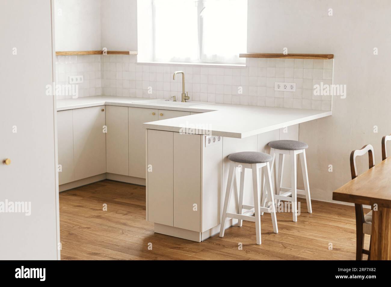 White and beige kitchen interior with bar Stock Photo by