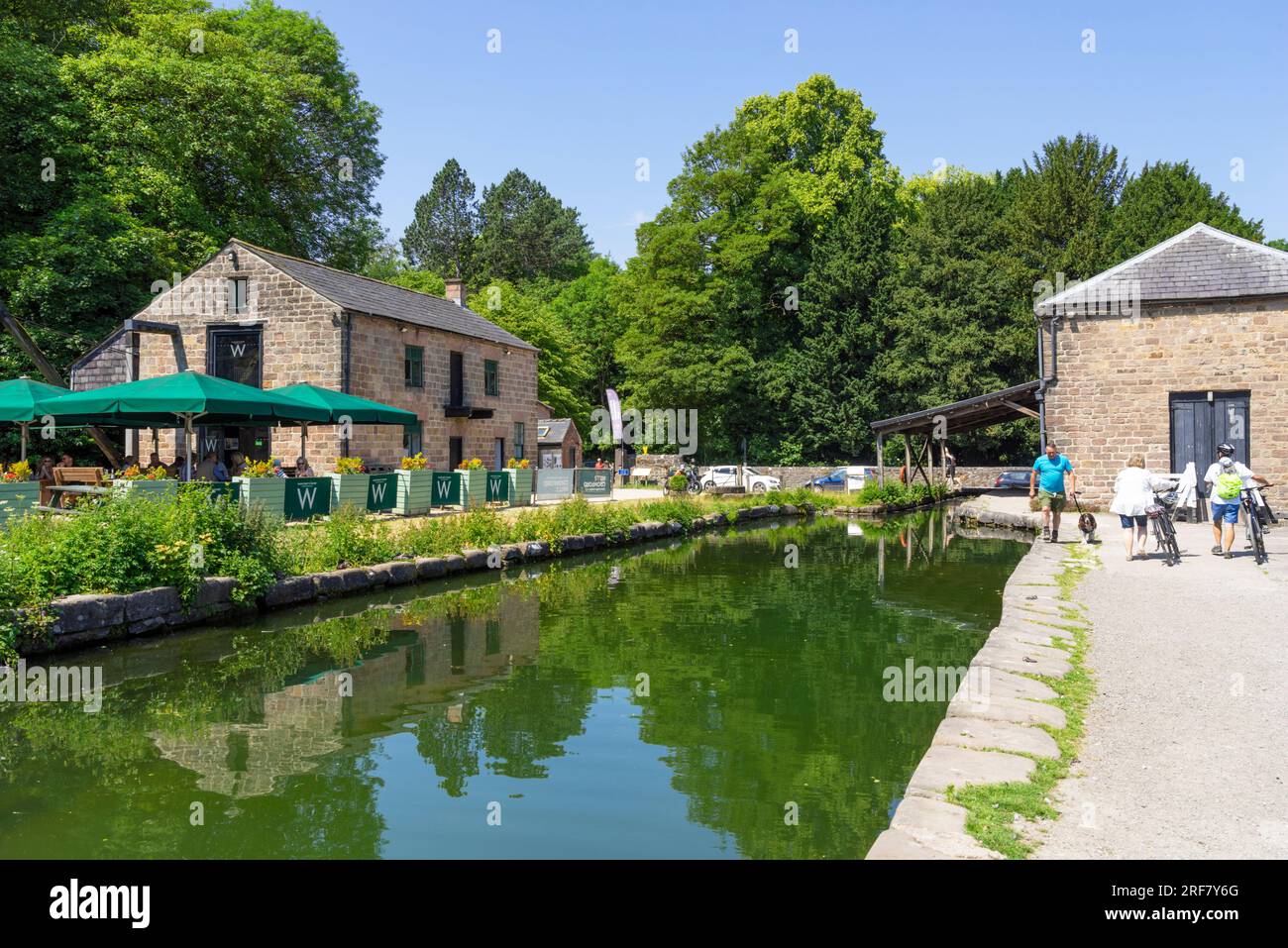 Cromford Canal and towpath with Wheatcrofts Wharf cafe and Gothic warehouse Cromford village Cromford Derbyshire Dales Derbyshire England UK GB Europe Stock Photo