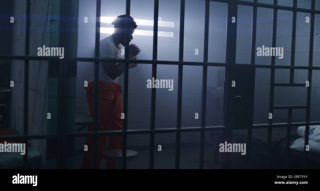 Male African American prisoner in orange uniform does shadow boxing in ...