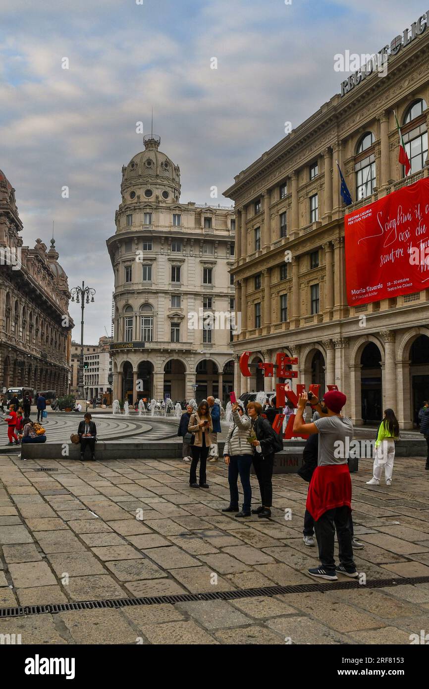 Tourists in Piazza De Ferrari, the main square of Genoa, with the Liguria Region Palace (right), in autumn, Genoa, Liguria, Italy Stock Photo