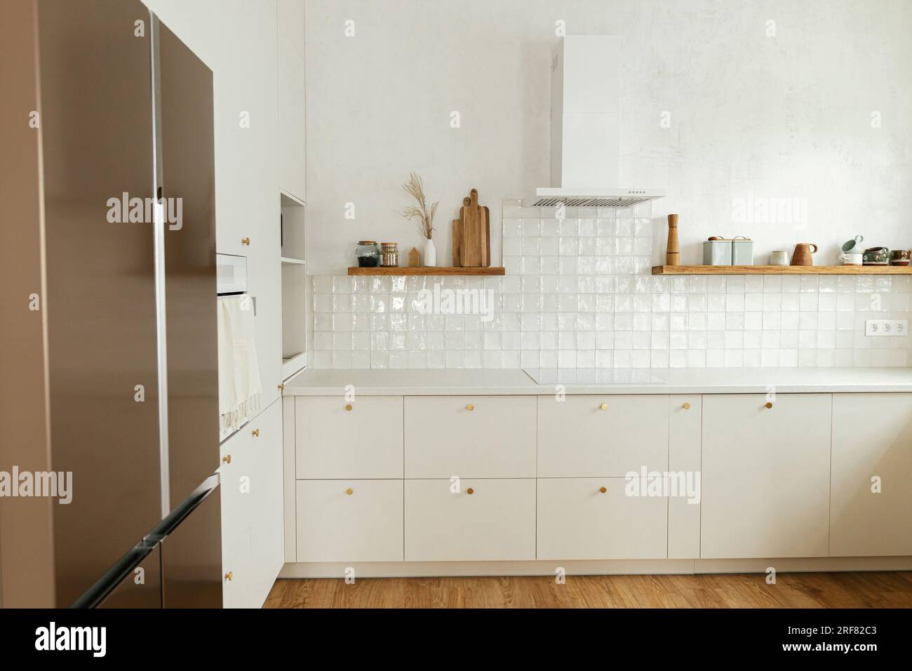 View of Modern kitchen interior. Stylish white kitchen cabinets with brass ...