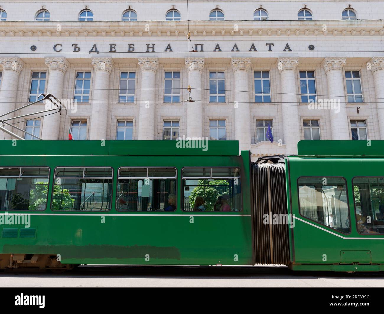 Green Tram outside the The Sofia Court House (Sadebna Palata, or Palace of Justice) in the City of Sofia, Bulgaria. August 01, 2023. Stock Photo