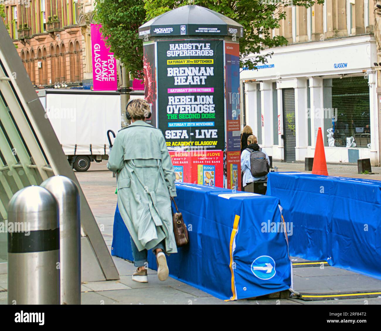 Glasgow, Scotland, UK 31st July, 2023. UCI anti terrorist barriers are installed for the world championships on the city streets and channelling crowds for bag check with traffic and barriers.  People use the street crowd control barriers. . Credit Gerard Ferry/Alamy Live News Stock Photo