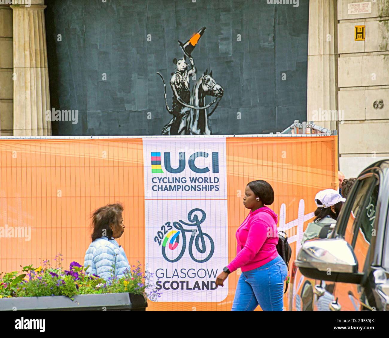 Glasgow, Scotland, UK 31st July, 2023. UCI anti terrorist barriers are installed for the world championships on the city streets and channelling crowds for bag check with traffic and barriers. Banksie cone headed duke  tribute on argyle street raises its hat to the uci crowd.. Credit Gerard Ferry/Alamy Live News Stock Photo