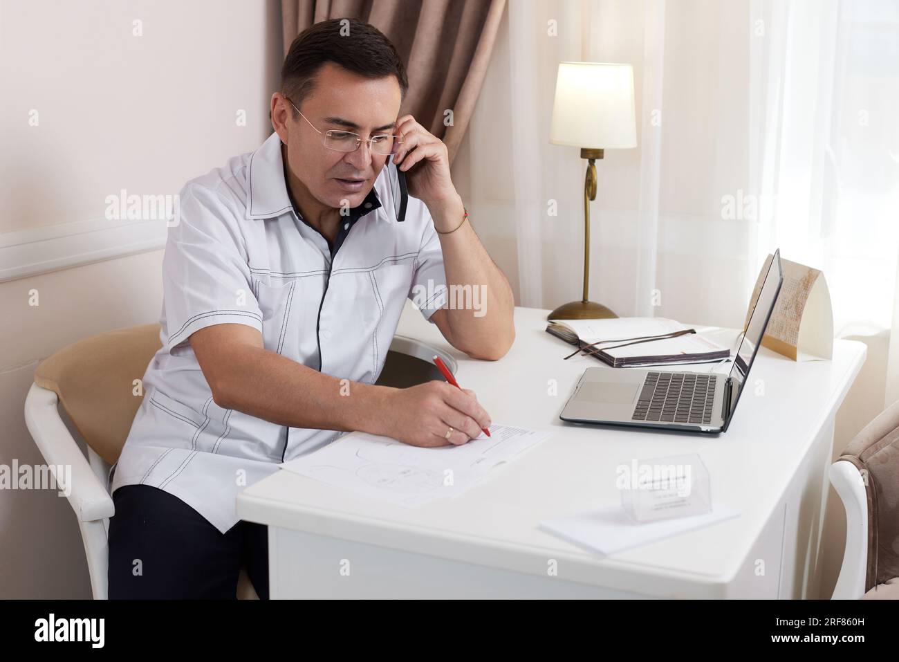 male doctor in white medical uniform using computer laptop Stock Photo