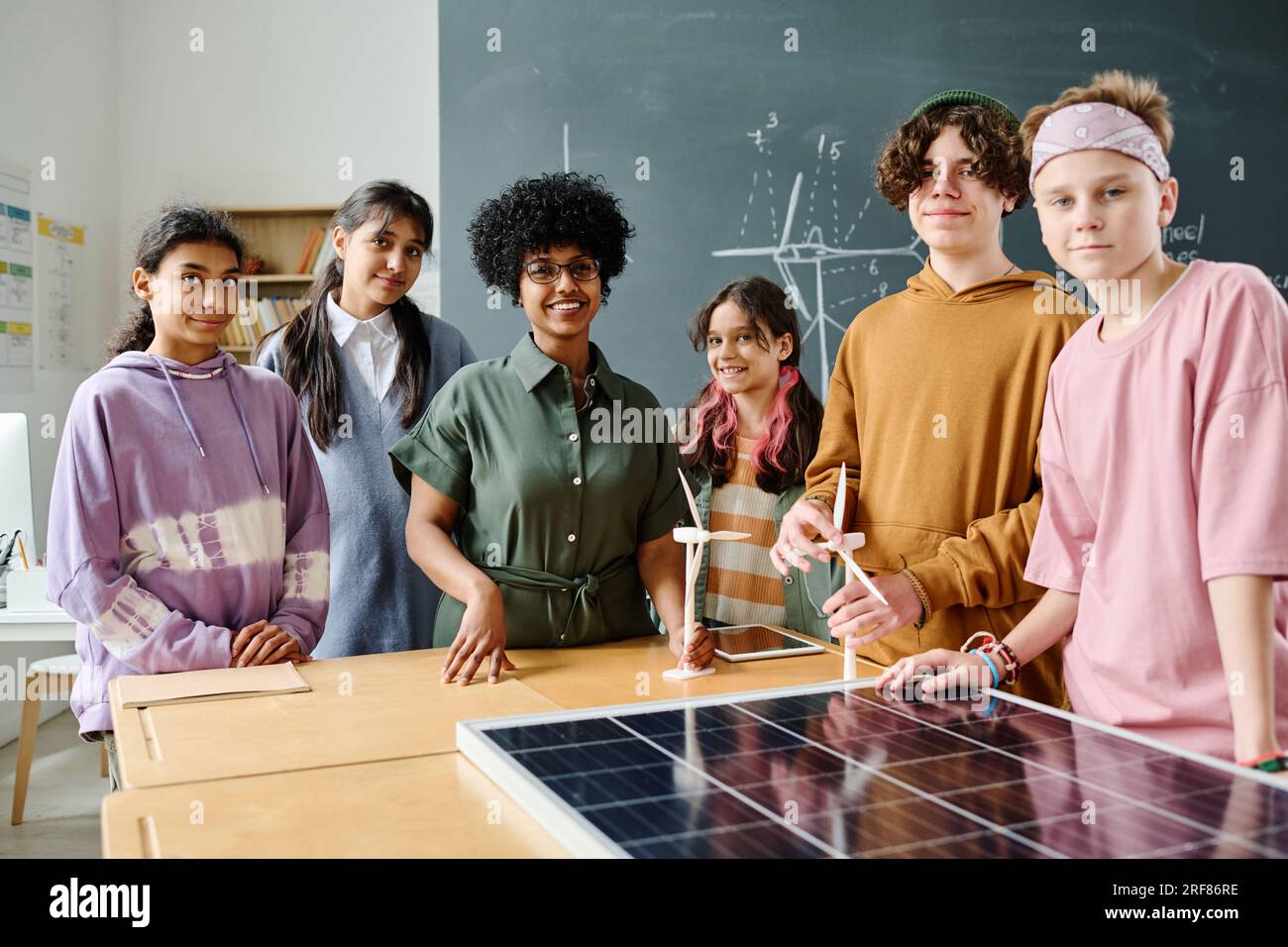 Portrait of teacher and students smiling at camera while standing in ...