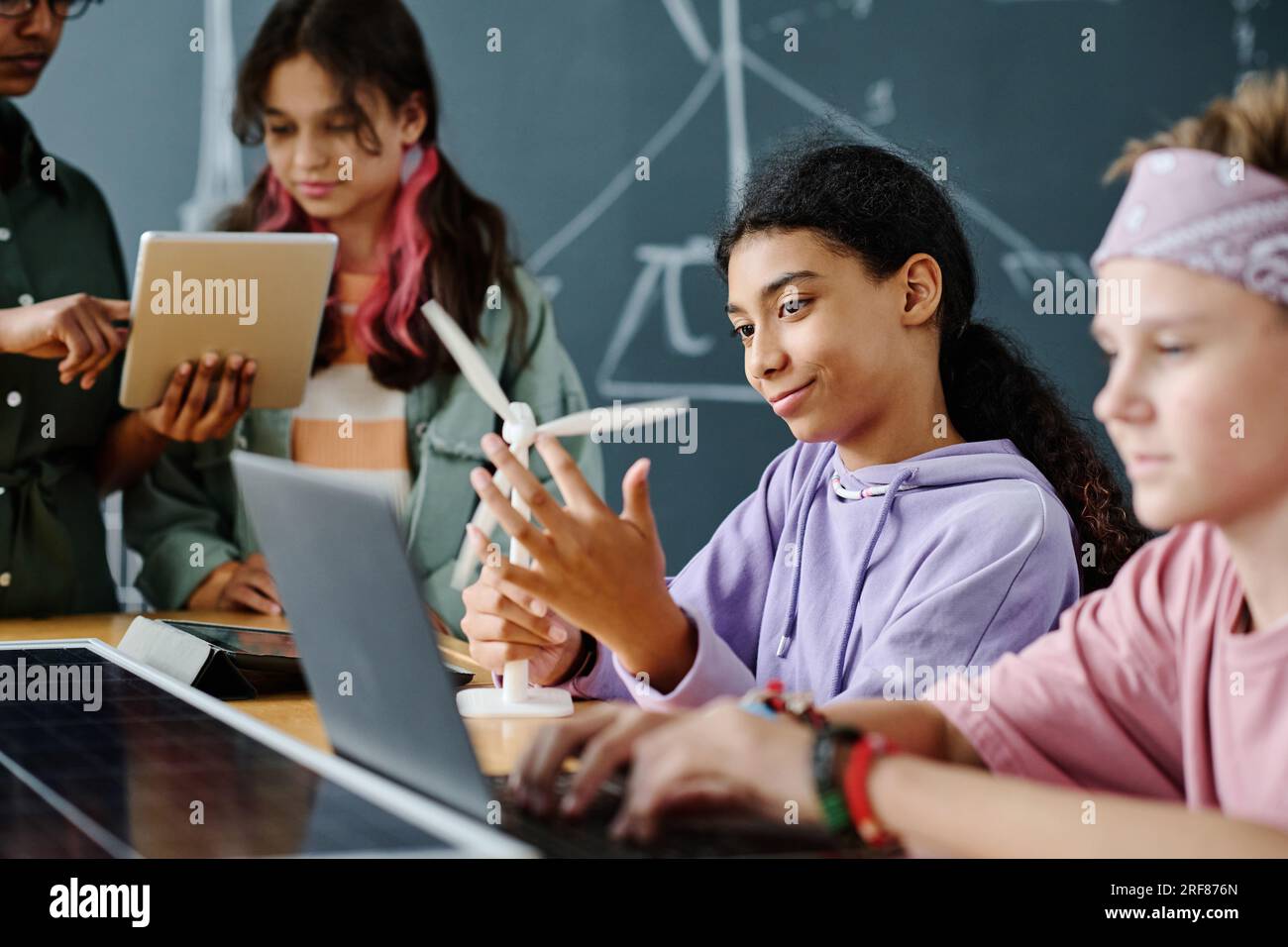 School children using computers with teacher in classroom Stock Photo ...