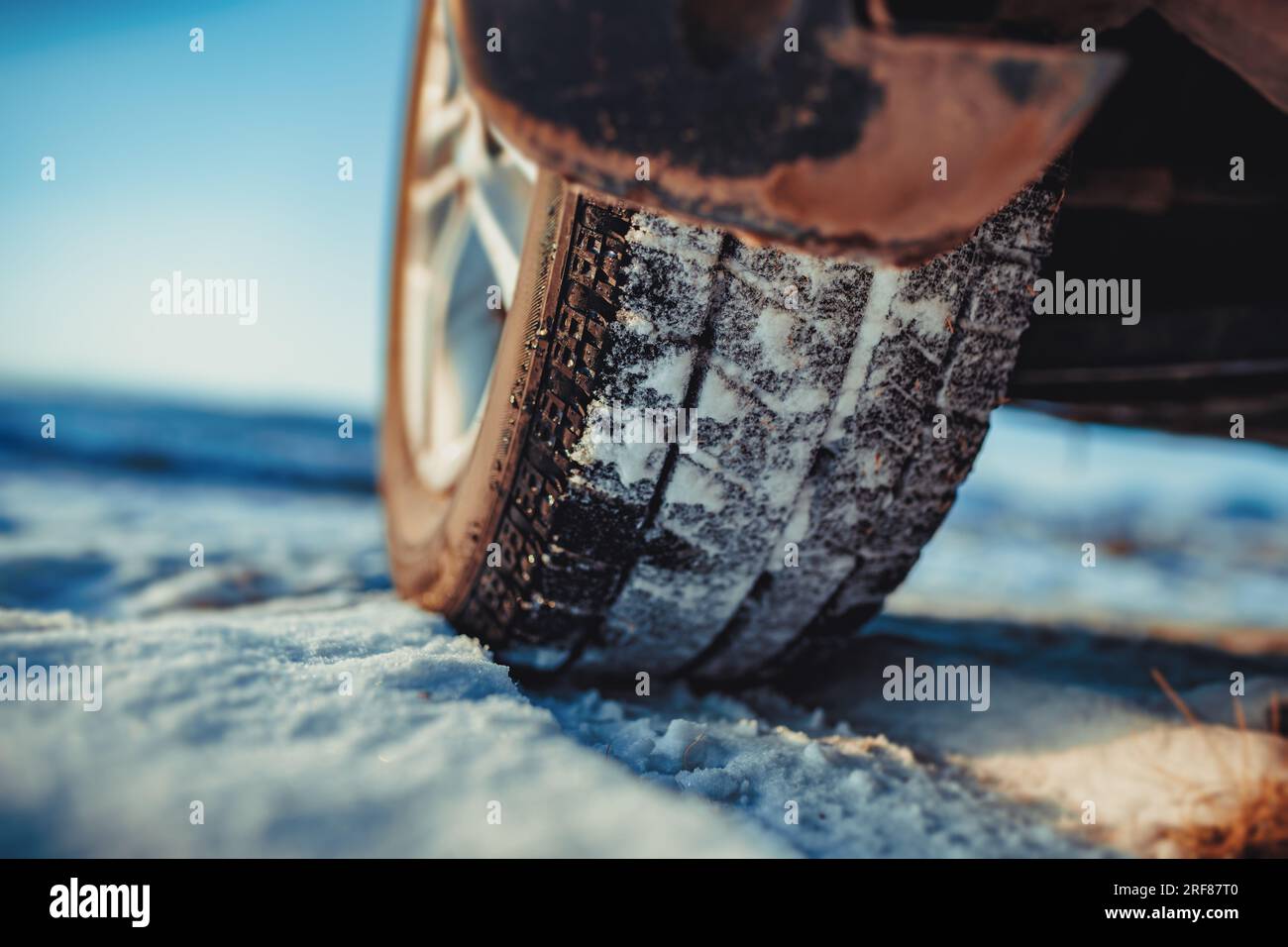 Car tire on snow at winter, focus on tire tread Stock Photo