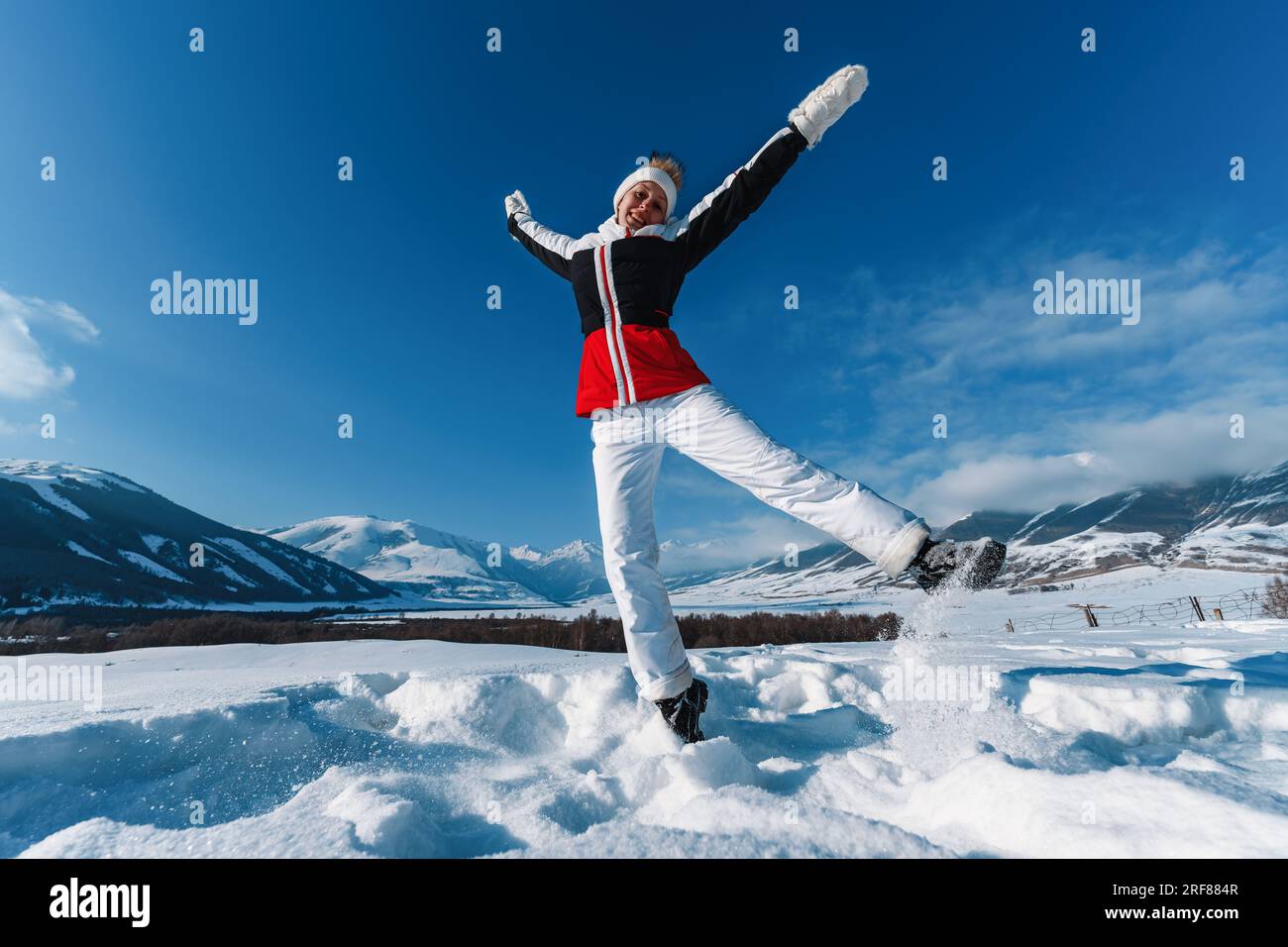 Young happy woman jumping on mountains background in winter season Stock Photo