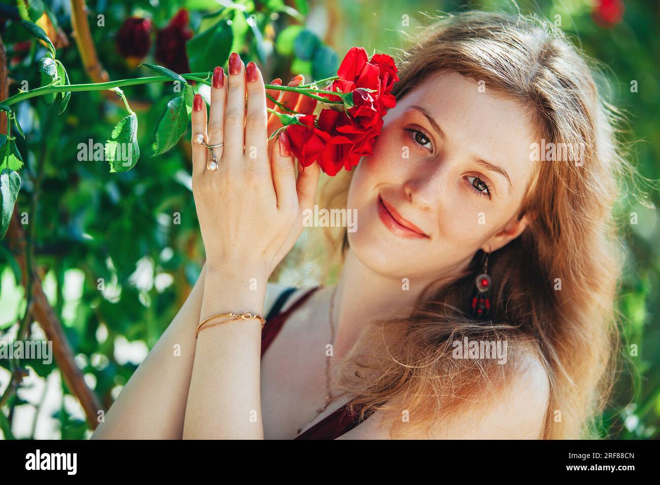 Young blond woman with red rose portrait Stock Photo - Alamy