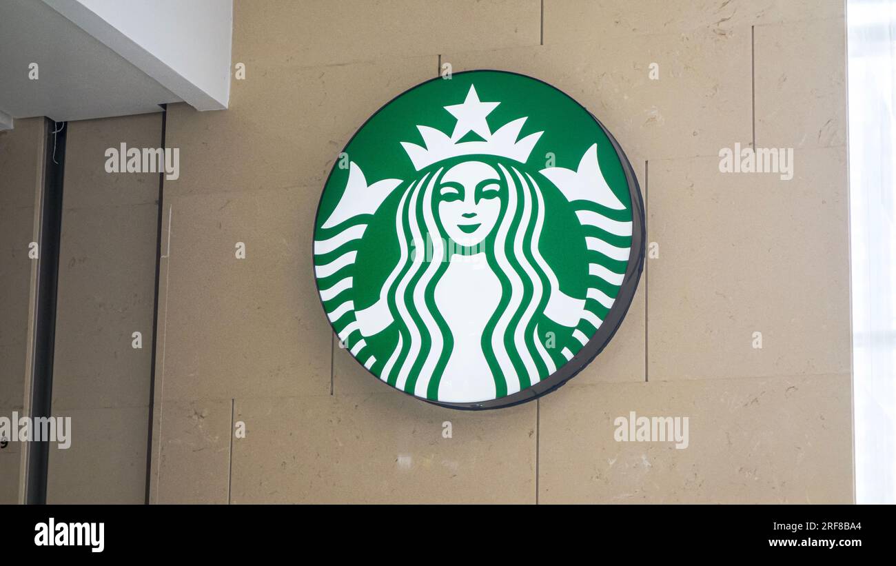 Nanning, China - July 1, 2013. Starbucks coffee logo on a wall. Starbucks Coffee is an American chain of coffee shops, founded in Seattle. Stock Photo