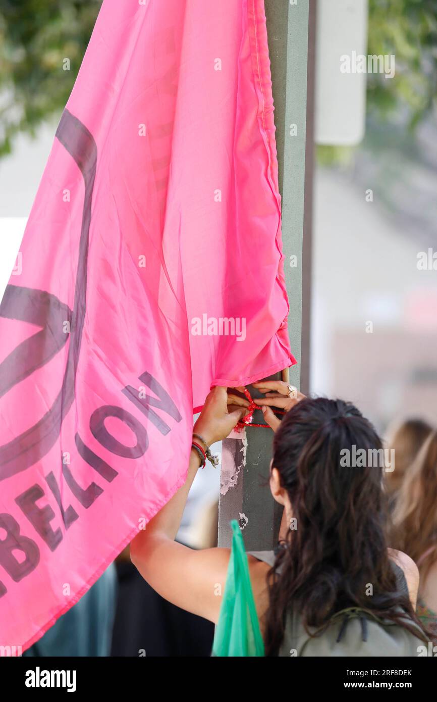 Pangea Eve adjusts an Extinction Rebellion flag during the Global