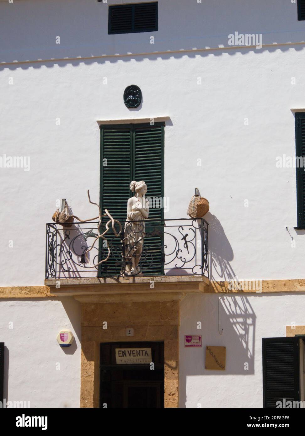 Una estatua de una mujer en el balcón de una casa en venta en Ciudadela, Menorca. .Una estatua de una mujer en el balcón de una casa en venta. Stock Photo